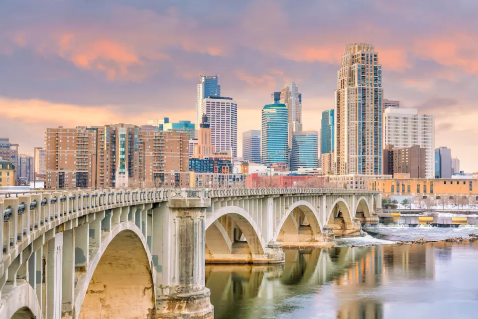 Downtown Minneapolis, Minnesota skylinw with stone arched brige in foreground.